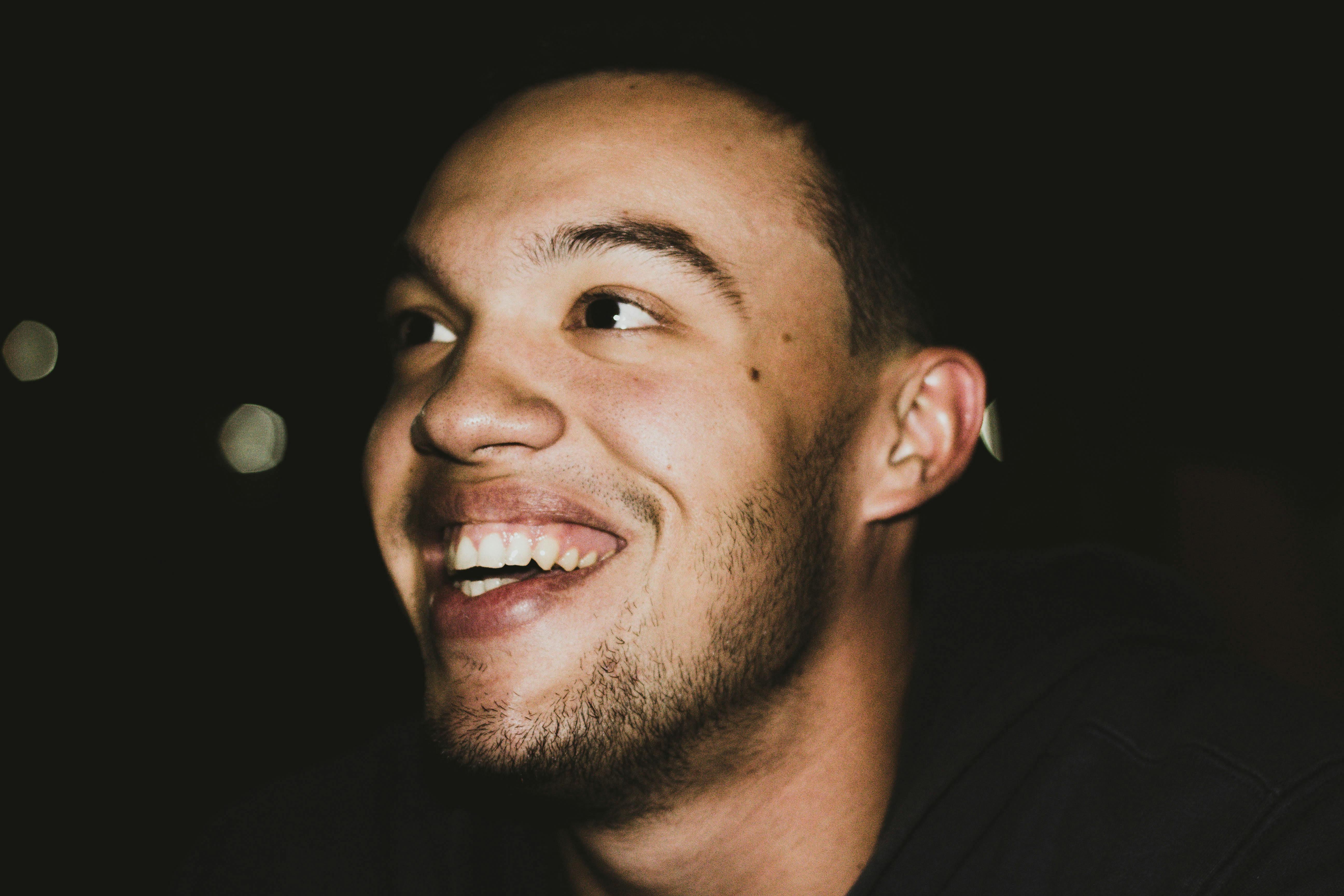A man smiling in the dark