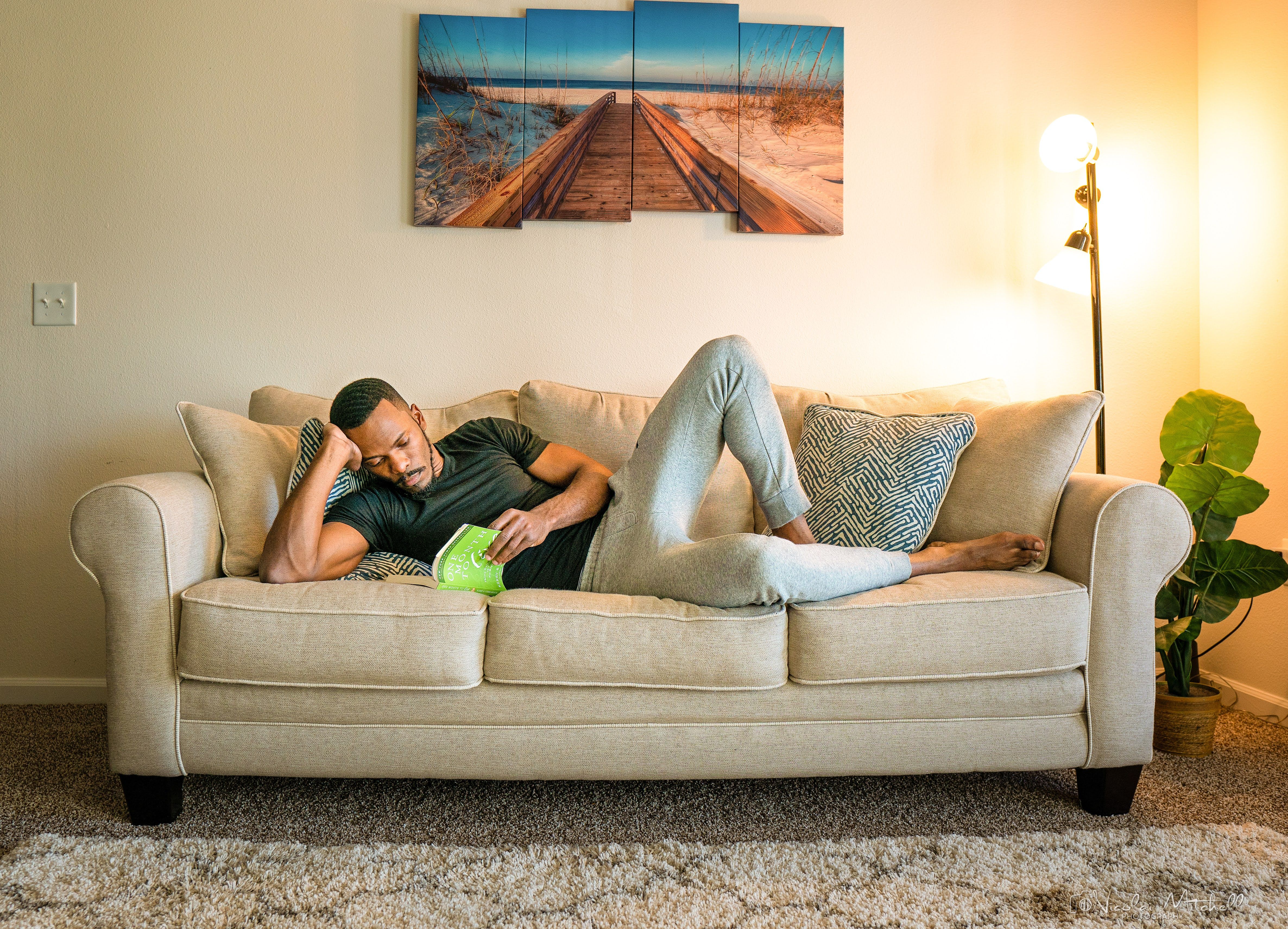 Man reading while laying down on the couch